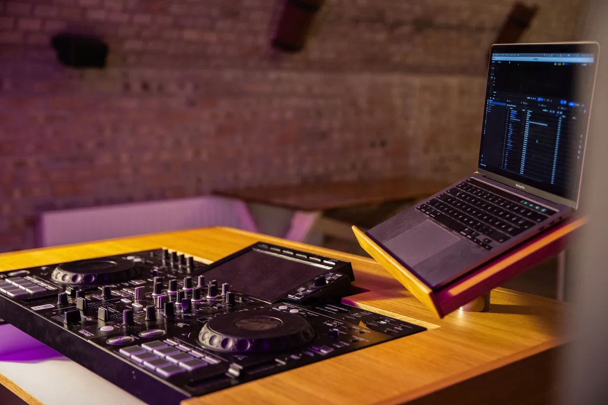 Mono munkafelület DJ-technikával és laptopállvánnyal.